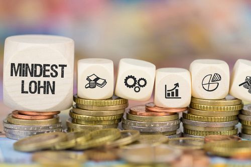 Foto: Münzen und Würfel mit Symbolen und Beschriftung Mindestlohn